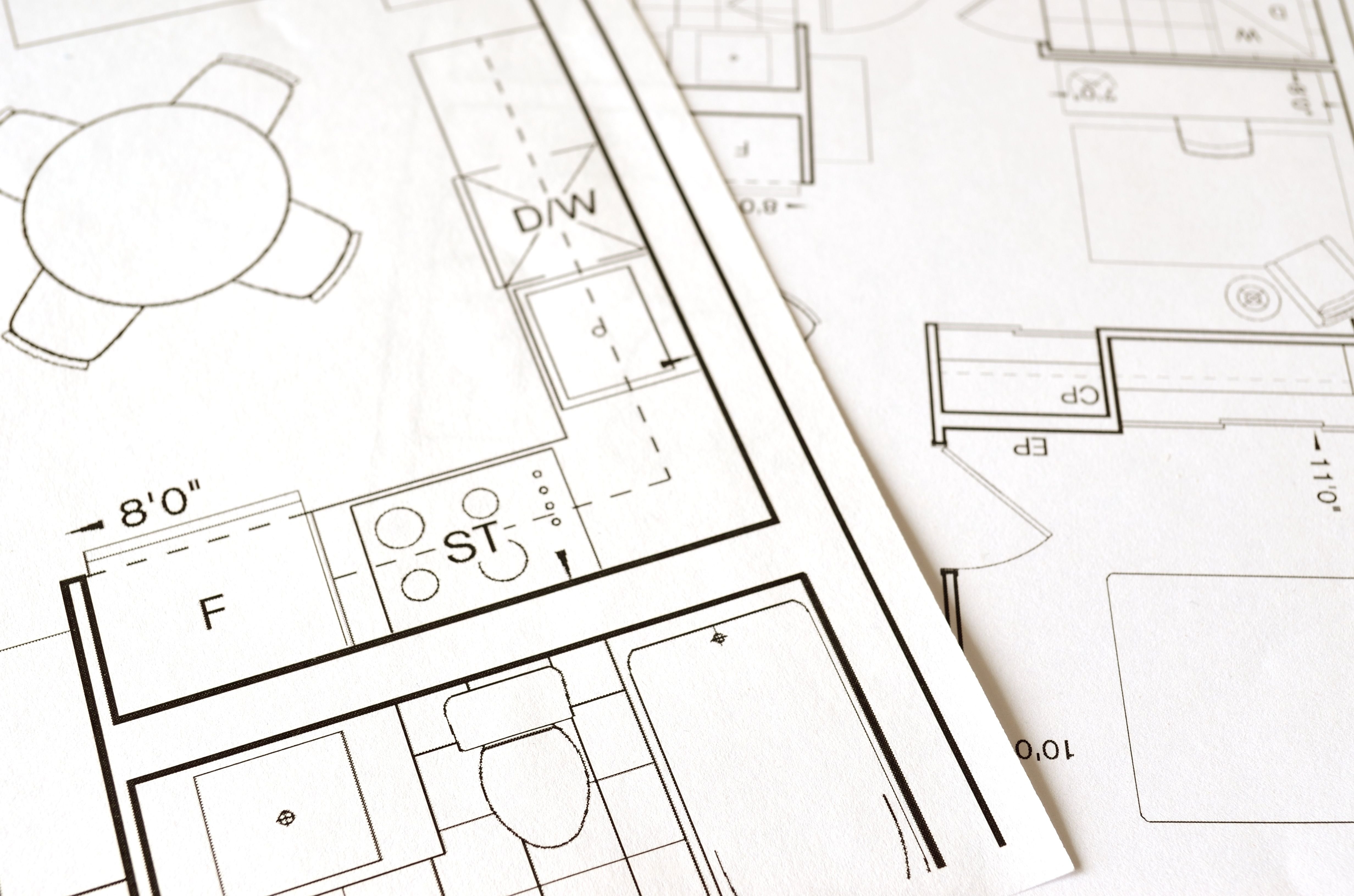 Some pages of an apartment floor plan blueprint lain out on a flat surface - showing renters and search engines the details they are asking about can boost AI search visibility.